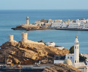 Lighthouse, watchtowers and white houses of traditional architecture of old town Sur in Sultanate of Oman.
