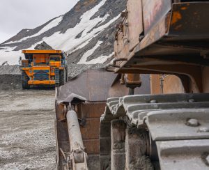 Powerful quarry bulldozer and gigat dump truck operating in the apatite mine in the Murmansk region. Mineral mining in the highlands.
