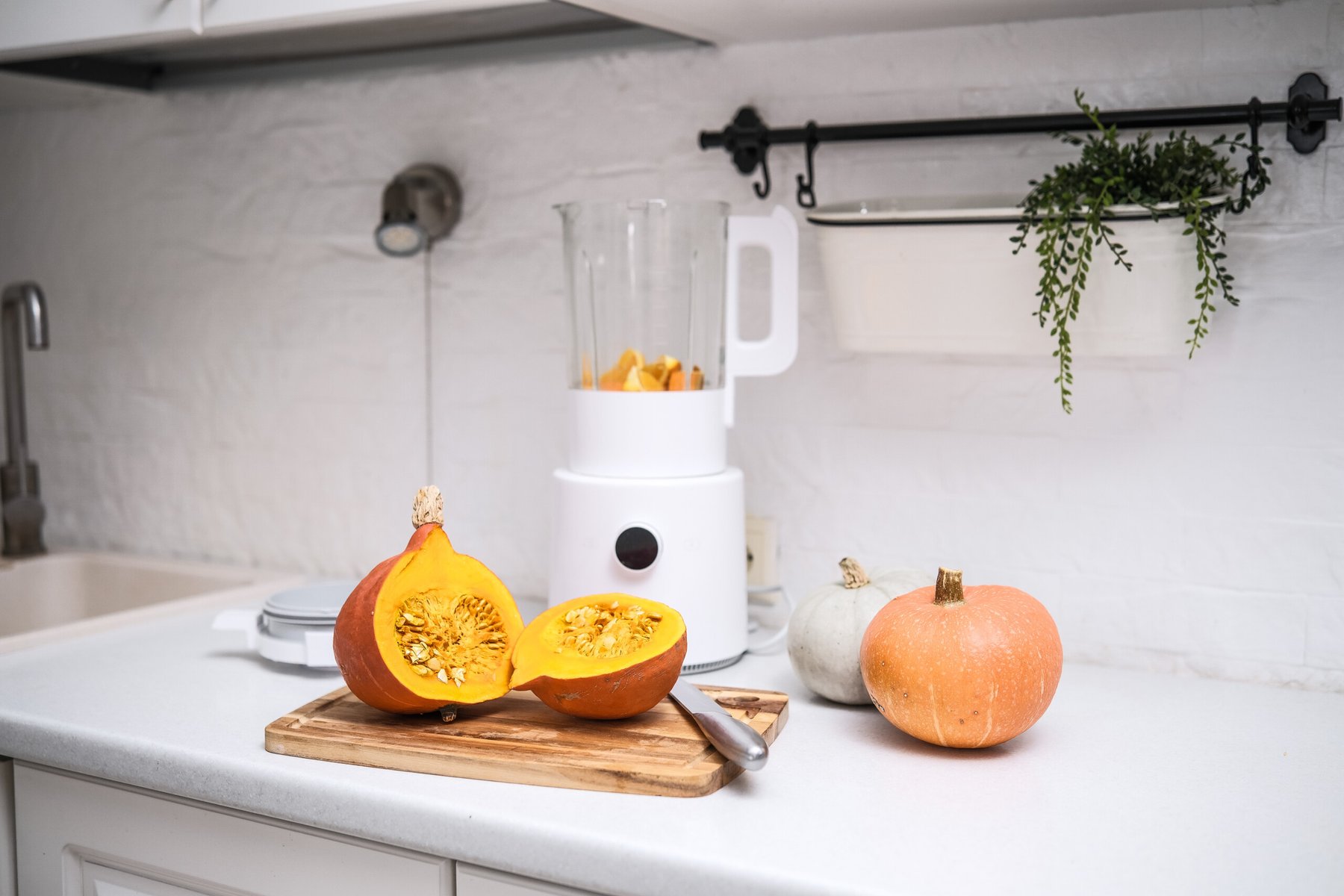 A warm and cozy kitchen filled with fresh, colorful pumpkins and a blender, ideal for delightful autumn cooking